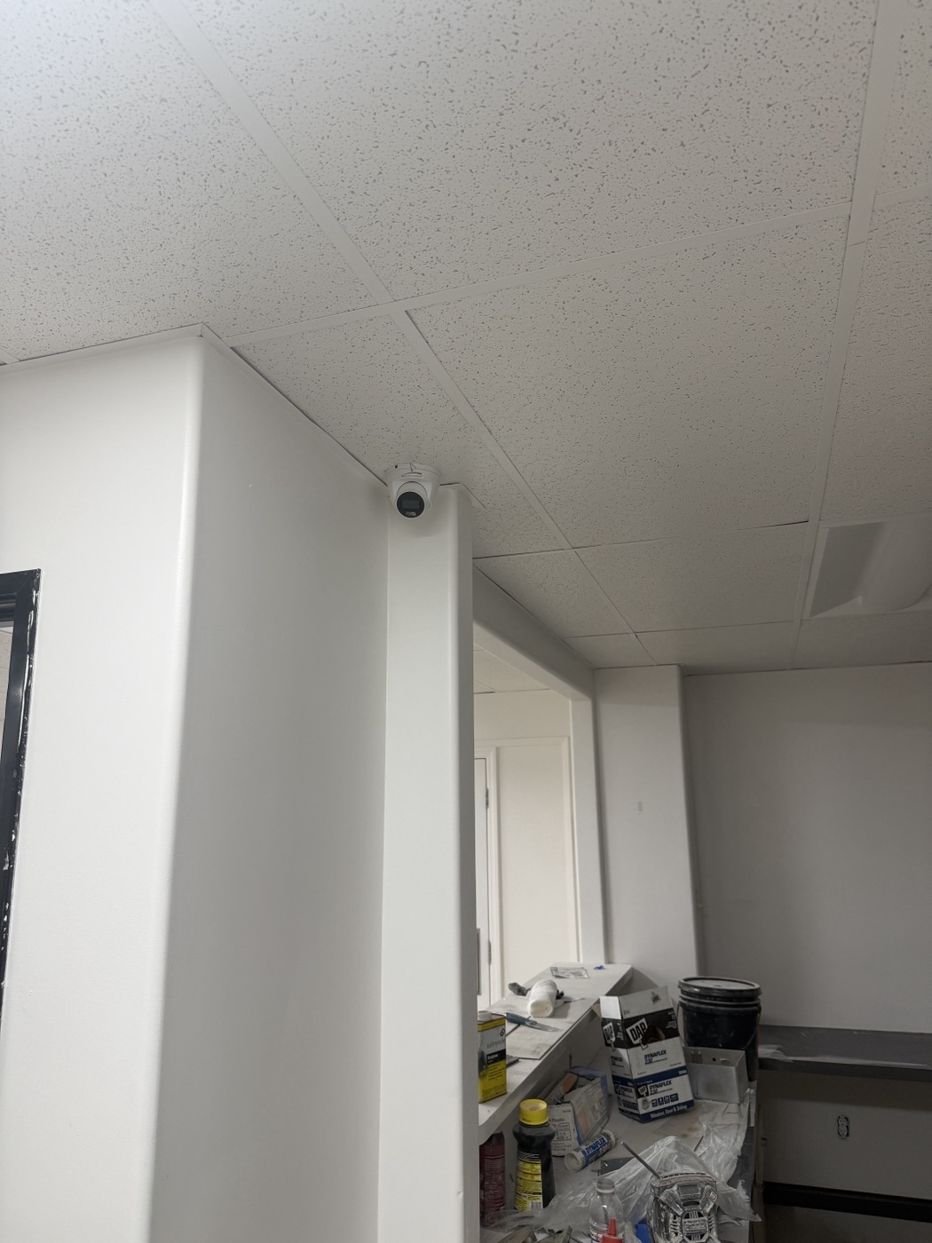 Turret security camera installed high at an interior dental office corridor