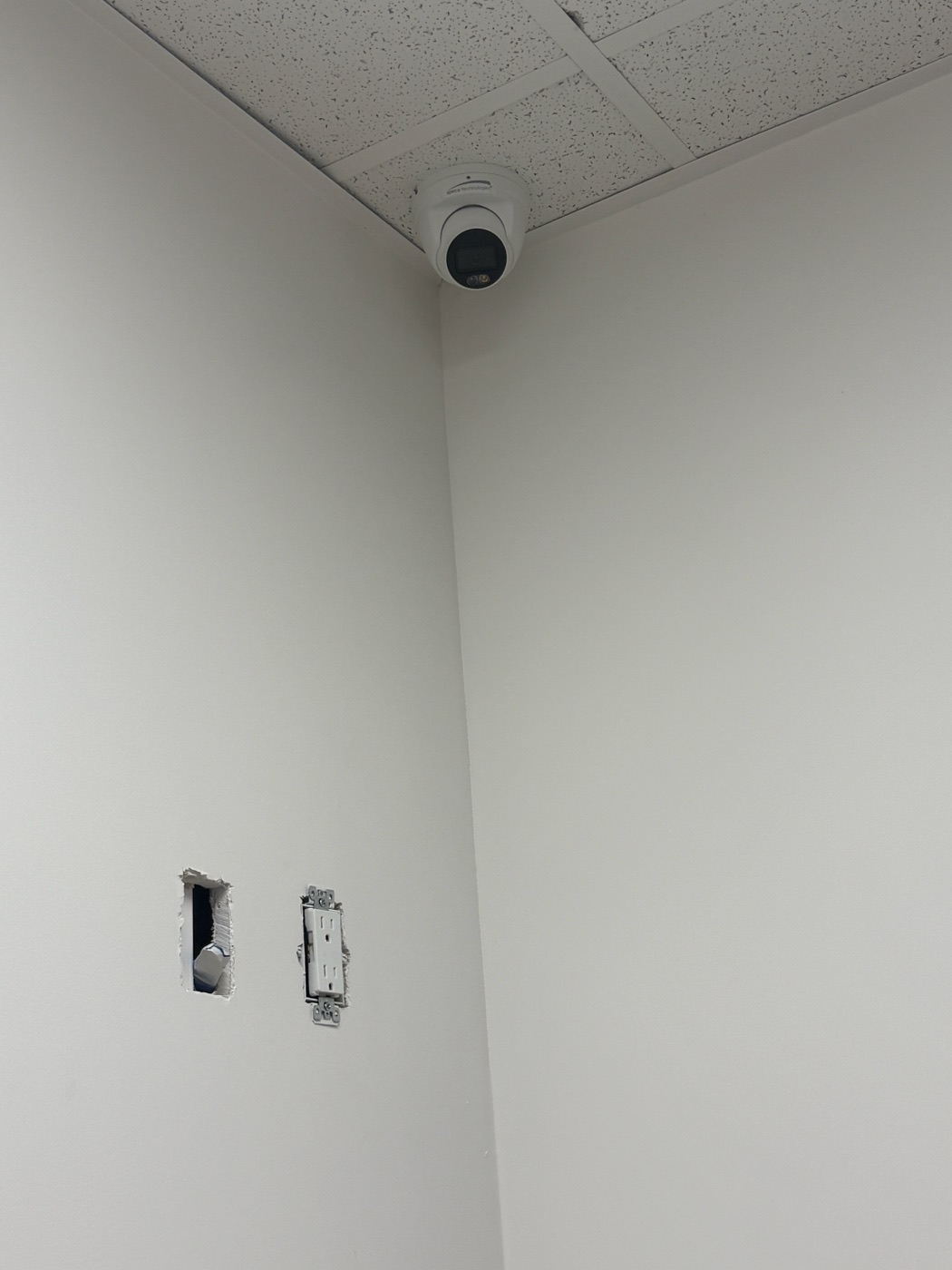 Close view of a turret security camera mounted at a dental office ceiling corner