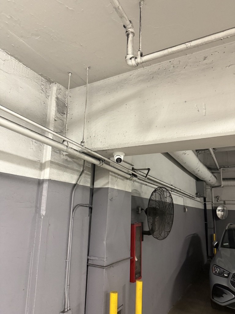 Security camera mounted below a parking garage beam