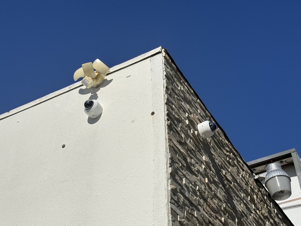 Two exterior turret cameras mounted on adjacent walls for parking lot coverage